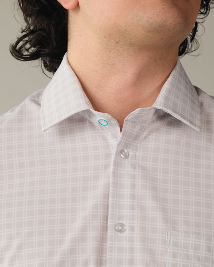 Man wearing grey shirt with small white windowpane. Top button has blue ring