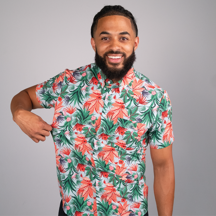 Man wearing a colorful tropical shirt against a gray background