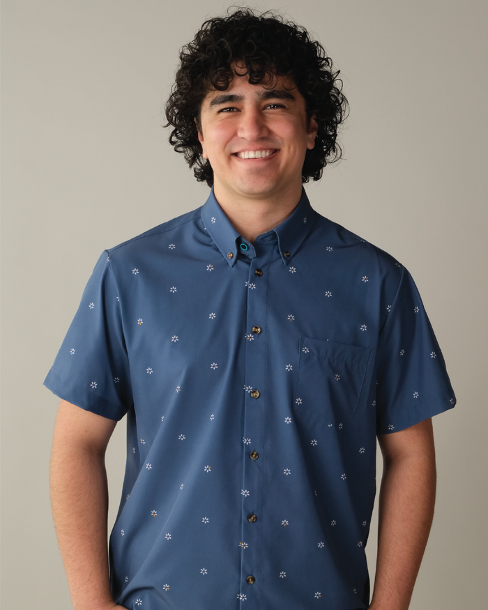 Man wearing a navy shirt with patterned white flowers