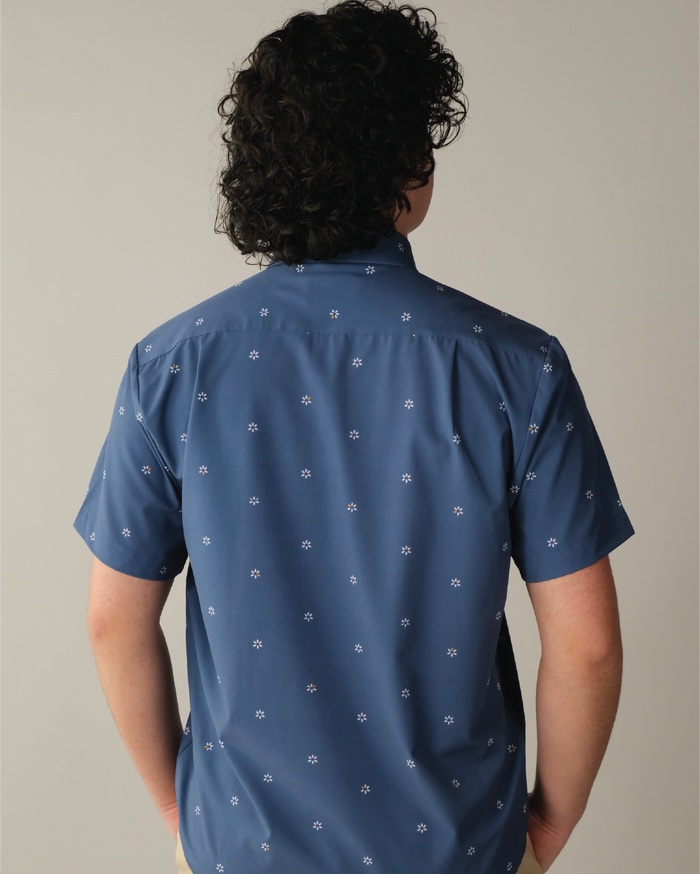 Man wearing a navy shirt with patterned white flowers
