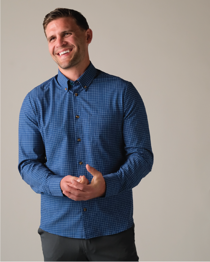 Man wearing a navy w/ white and blue check shirt with toroise shell buttons