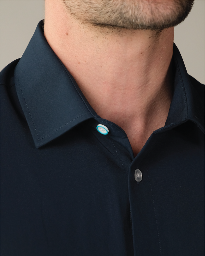 Man wearing a navy dress shirt, blue ring on top button