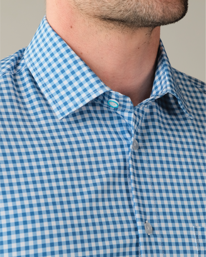 Man wearing royal blue and white gingham shirt. Top button is blue