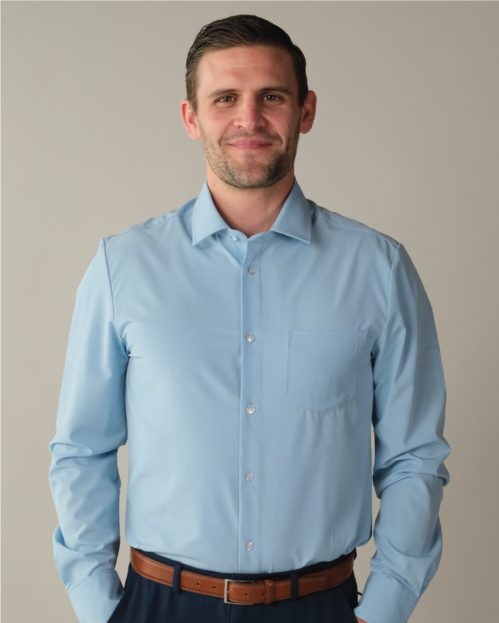 Man wearing a french blue dress shirt against a plain background