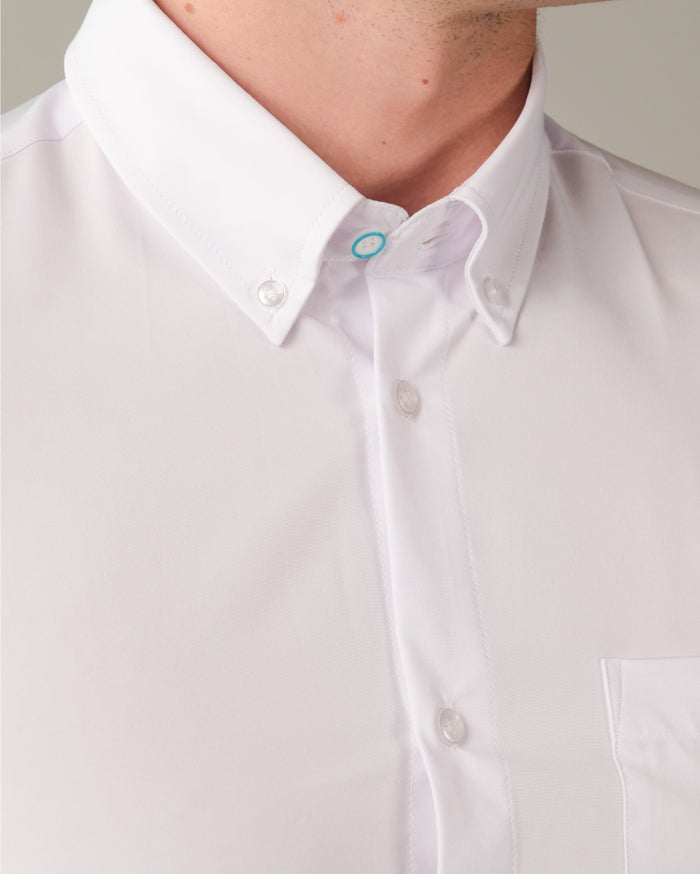 Close up of a white dress shirt with designed top button and button down collar