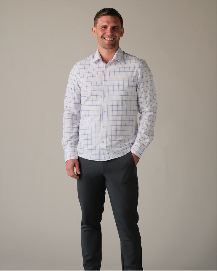 Man wearing a white shirt with navy and grey grids and dark pants