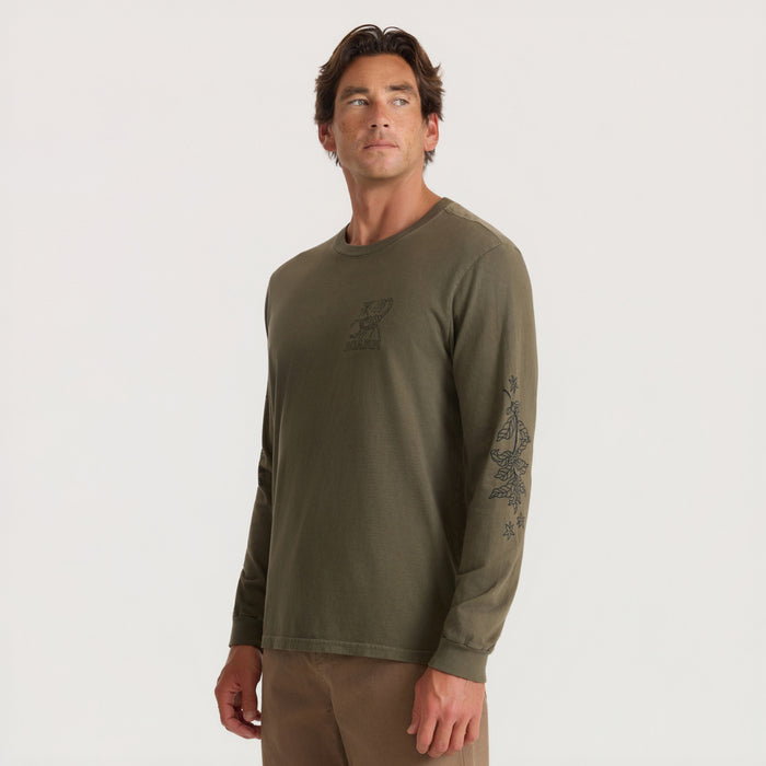 Military green long sleeve tee with small chest graphic and decorative sleeve print, worn by model against neutral background