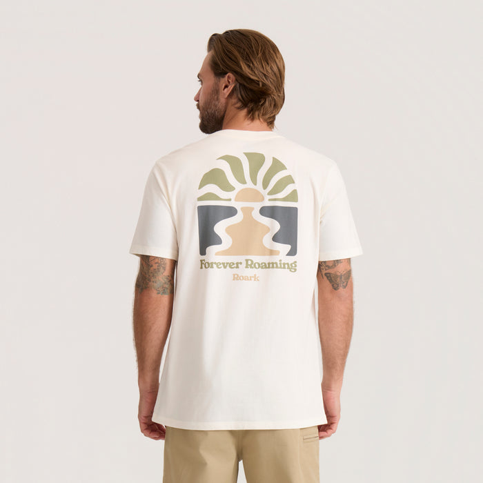 Cream-colored Roaming Premium Tee with geometric sun and landscape graphic on back, worn by man with tattoos