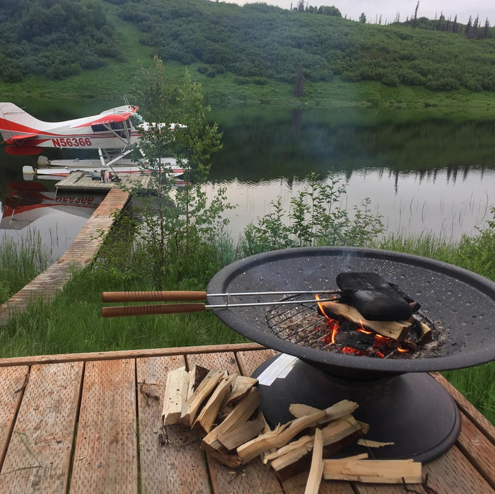 Rome Industry Double Pie Iron 1605 in use over open campfire pit beside lakeside dock - Lifestyle Shot | United RV Parts