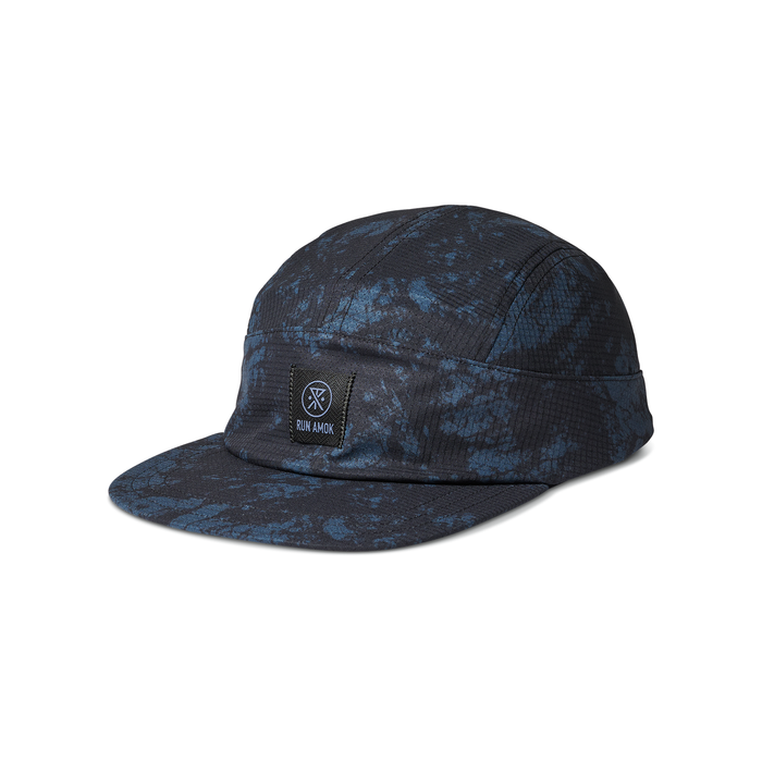 Run Amok five-panel cap in a blue and black splatter pattern, featuring a structured front panel with a woven patch logo. Perfect for outdoor adventures and urban style."