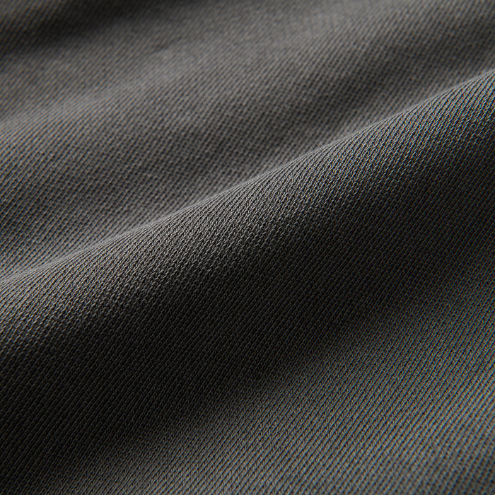 Close-up of textured grey and silver woven fabric, embodying durability and style for adventure and outdoor gear by Roark.