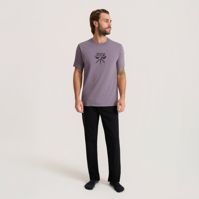 Man wearing purple Safe Camper Premium Tee with small graphic print, styled with black pants, full-length front view on white background