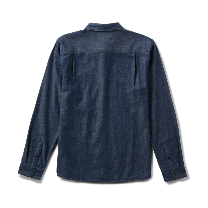 Close-up view of a rugged denim button detail on Roark adventure apparel