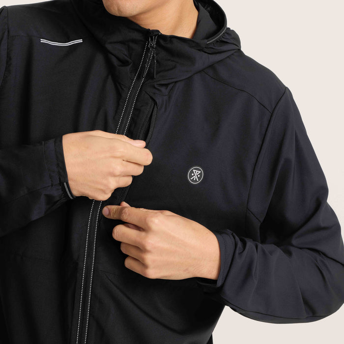 Close-up of the Roark black windbreaker jacket being zipped, emphasizing its sleek design and practical features for outdoor wear.
