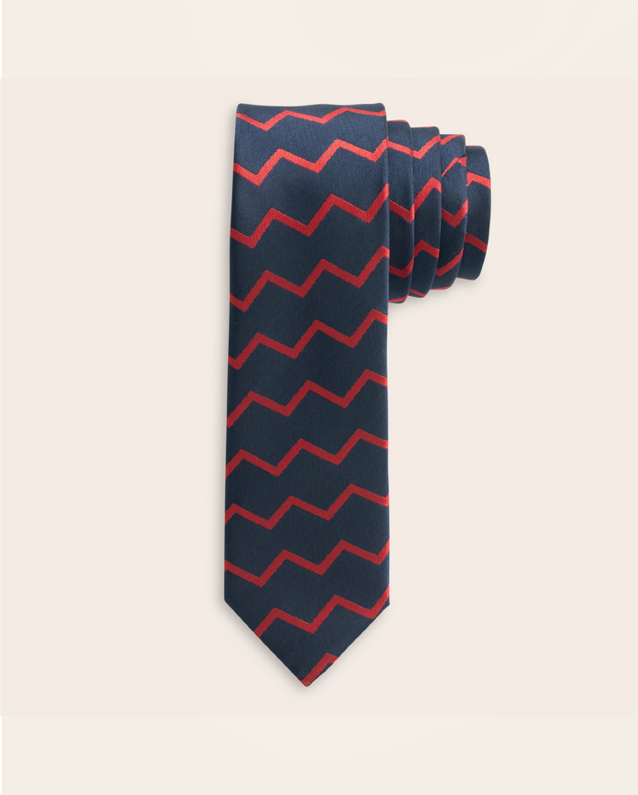 Navy tie with red zigzag pattern on a beige background