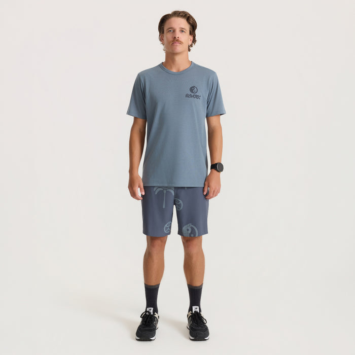 Man wearing slate blue t-shirt and ebony Serrano active stretch shorts with logo print, full-length front view on model