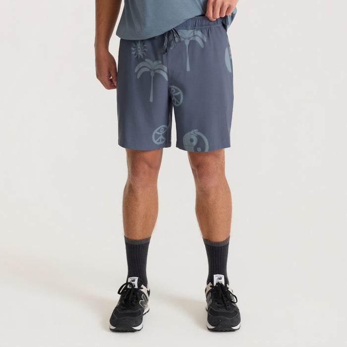 Ebony Serrano Active Stretch Shorts with tropical palm and sun print, worn on model with black socks and sneakers