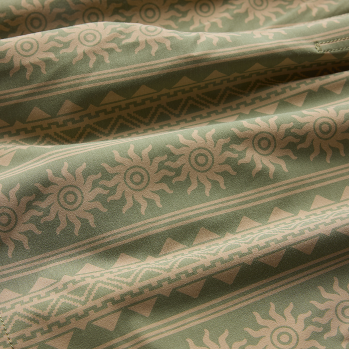 Shorey boardshorts in dusty sage green with tan geometric and sun stripe pattern, folded flat lay detail view