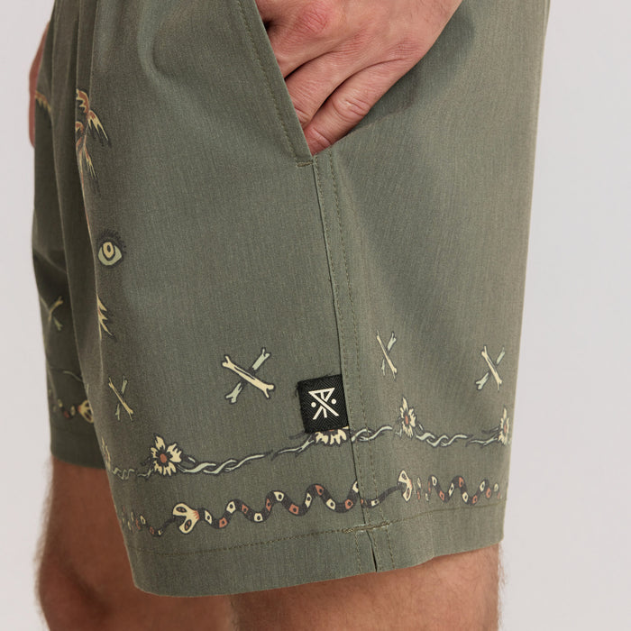 Sage green Shorey Boardshorts with embroidered details including crossed bones and decorative trim, shown on model's waist and leg