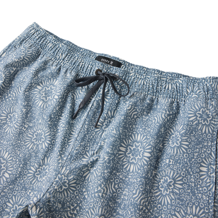Slate blue Shorey Boardshorts with white floral print, elastic waistband and black drawstring, flat lay detail shot