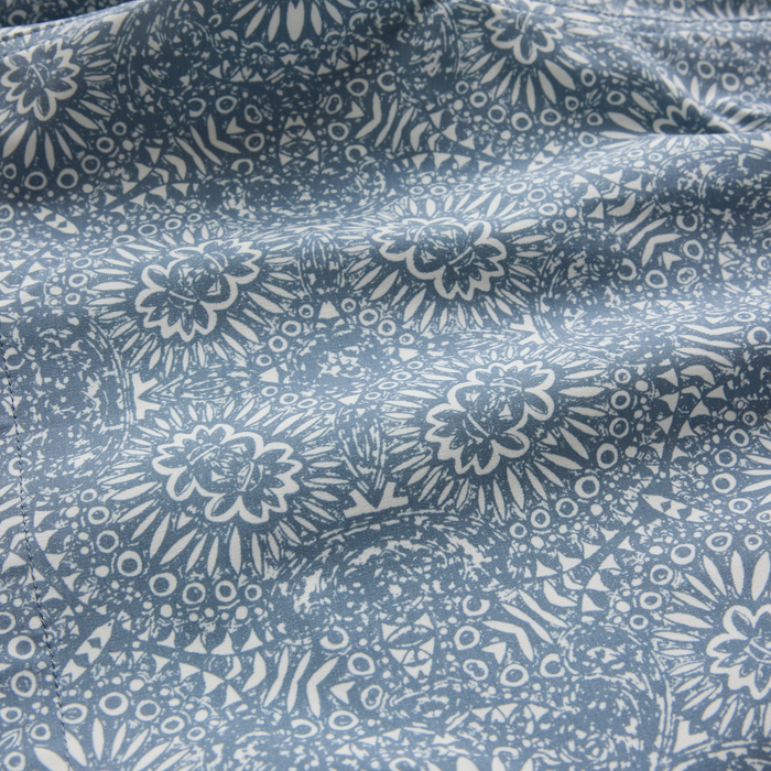 Slate blue Shorey Boardshorts with intricate floral and geometric pattern in cream, displayed in flat lay detail shot