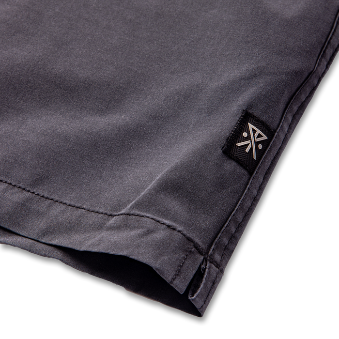 Pair of grey denim Bermuda boardshorts with visible pockets, designed for adventure and travel