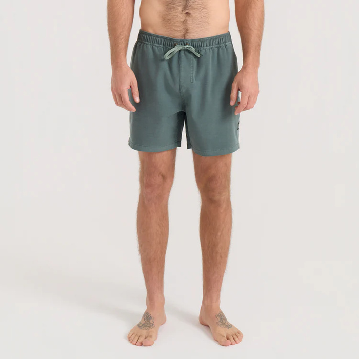 Man wearing sage green Shorey boardshorts with drawstring waist, standing against white background in front view