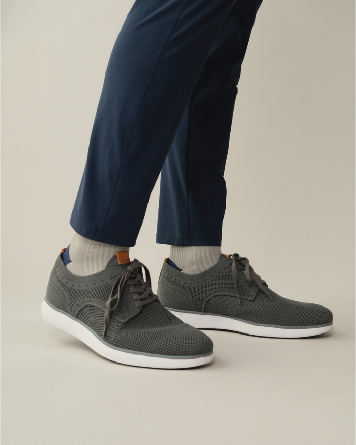 Grey shoe with white outsole worn with midnight navy pants