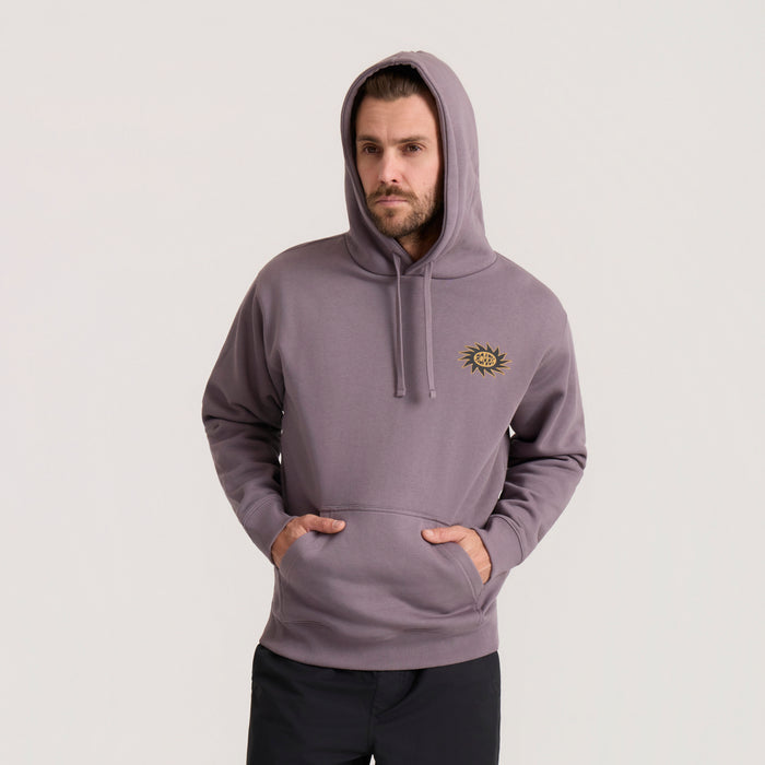 Mauve Sunbeam Hoodie with gold sun embroidery on chest, worn by man with hood up and hands in pockets