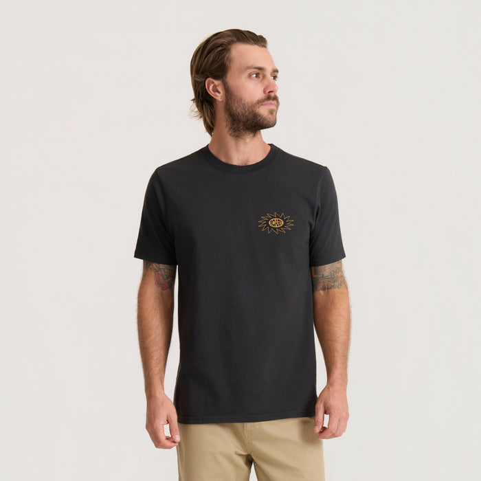Black Sunbeam Premium Tee with small gold sun embroidery on chest, worn by male model with tattoos on beige background