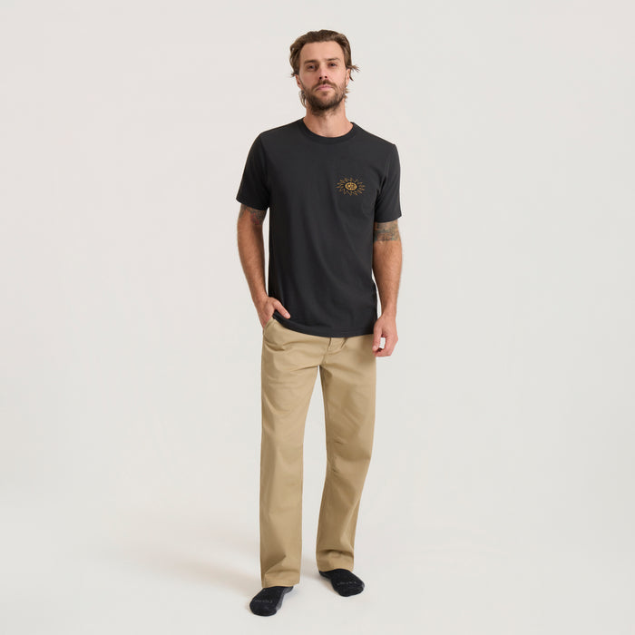 Black short sleeve t-shirt with gold sun chest graphic worn by man with khaki pants in lifestyle shot