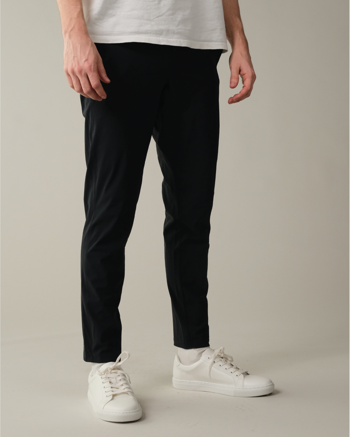 Person wearing pitch black pants and white sneakers