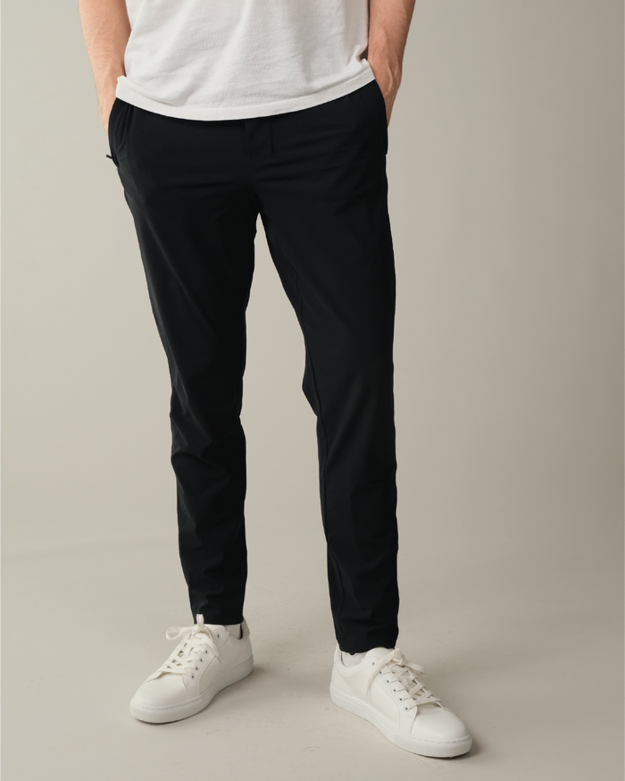 Person wearing pitch black pants and white sneakers