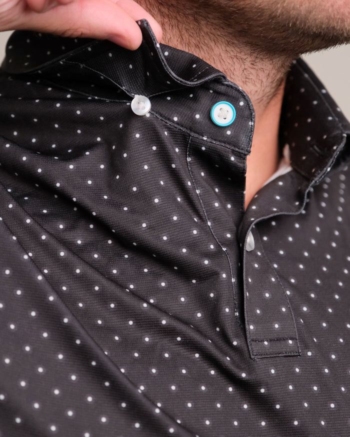 Close-up of a black with white polka dots short sleeve polo shirt hidden button collar