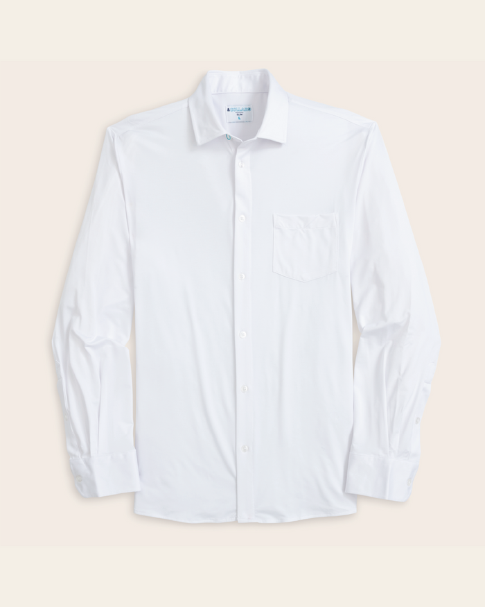 A white, long-sleeved, button-up shirt with a collar with an off white background.