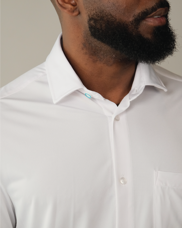Close up of the collar of the white button up dress shirt being worn.