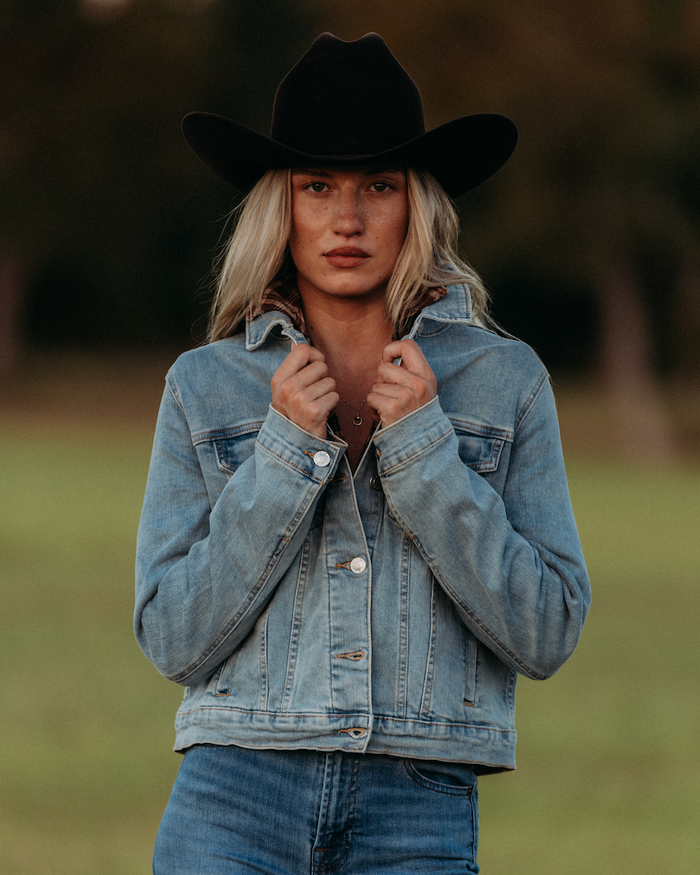 Woman in a denim jacket and black hat