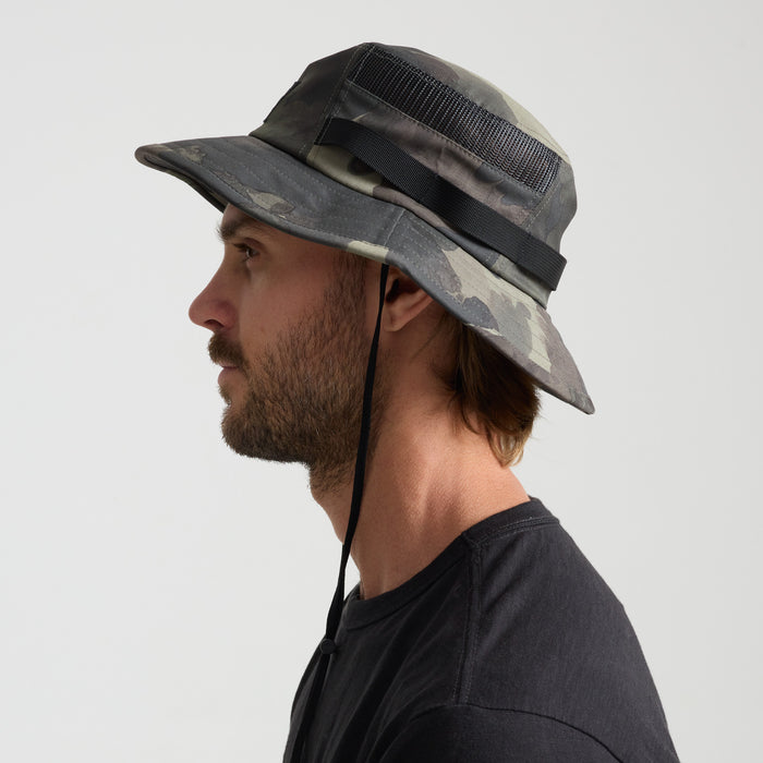 Camouflage adventure hat in a fedora style, perfect for outdoor explorations and travel, displayed in a natural setting.