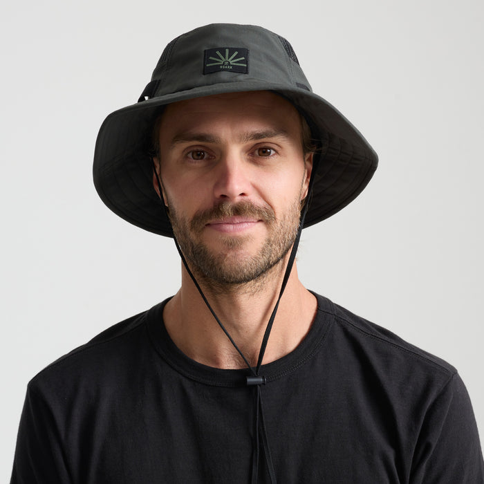 Fedora and sun hat on a rustic wooden surface, embodying Roark's adventure and travel spirit.