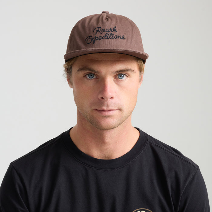 Assorted Roark adventure caps including a baseball cap and sun hat in outdoor setting