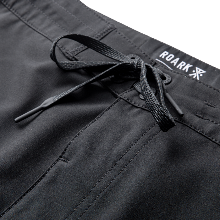 Adventurous black Roark Venture backpack displayed against a rugged outdoor backdrop, emphasizing durability and style for travel and exploration.