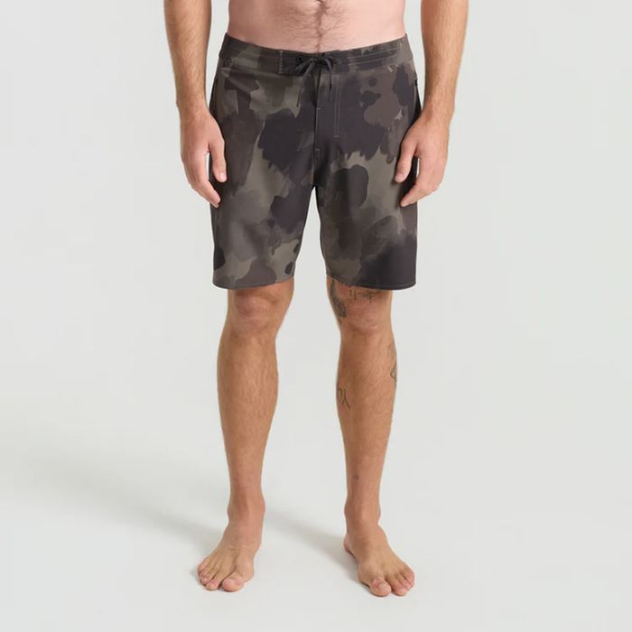 Calf balancing in boardshorts on a scenic outdoor adventure, embodying the spirit of Roark's travel and exploration ethos.