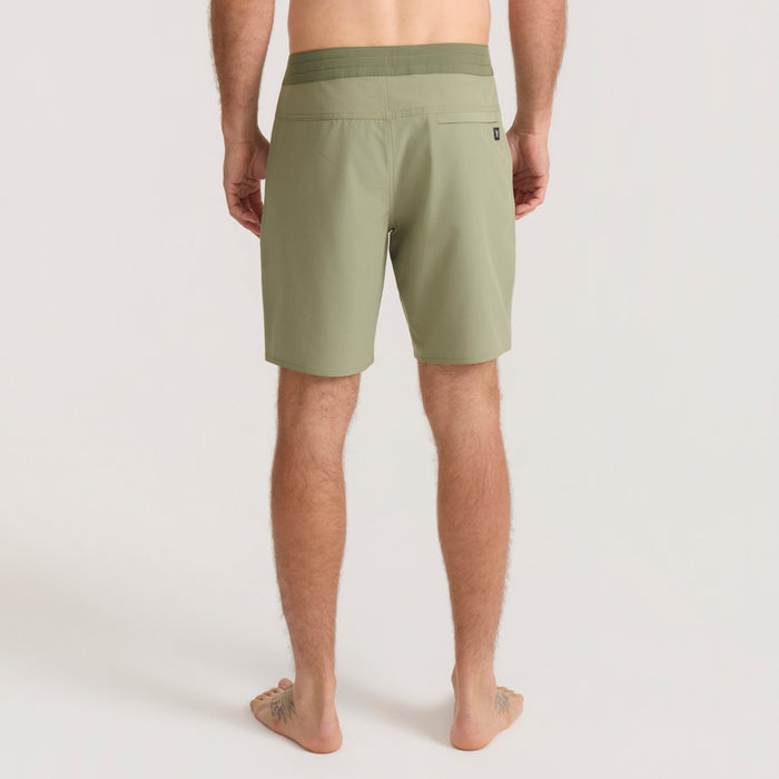 Man wearing sage green Venture Hybrid Trunk shorts shown from behind, displaying back pockets and relaxed fit design