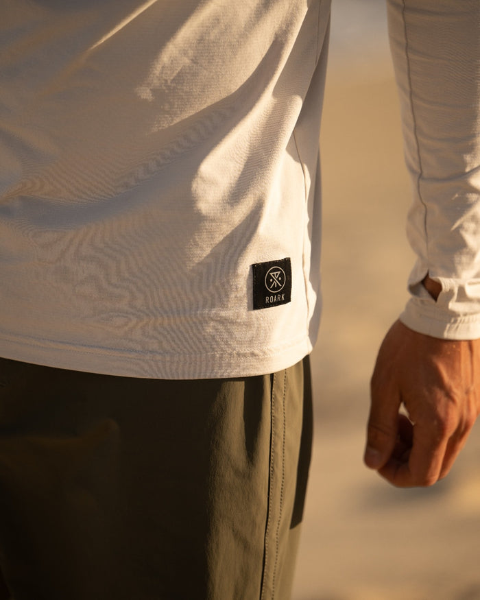 Close up view of Surfer wearing a Venture UPF hoodie paddling out on a surfboard in the ocean, ready for a day of water sports.