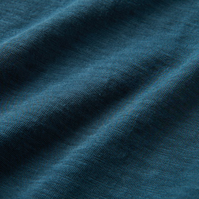Close-up of textured navy blue woven fabric resembling denim or wool, capturing the essence of rugged outdoor adventure gear by Roark.