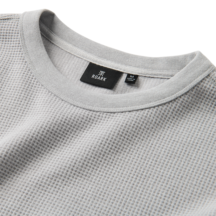 Close-up of Roark's high-performance active shirt featuring durable white textile in the sleeve and neck areas, perfect for outdoor and adventure travel.