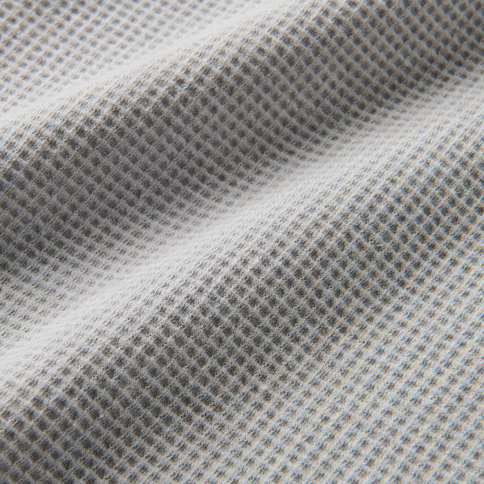 Close-up of a high-quality grey mesh textile from Roark, perfect for durable outdoor and adventure gear