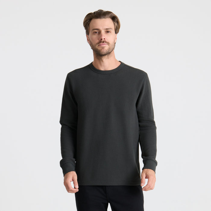 Model wearing a grey long-sleeved active shirt paired with denim, featuring a rugged outdoor look perfect for adventure and travel