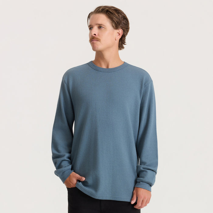 Slate blue thermal long sleeve tee on model, shown from front with hands in pockets against neutral background
