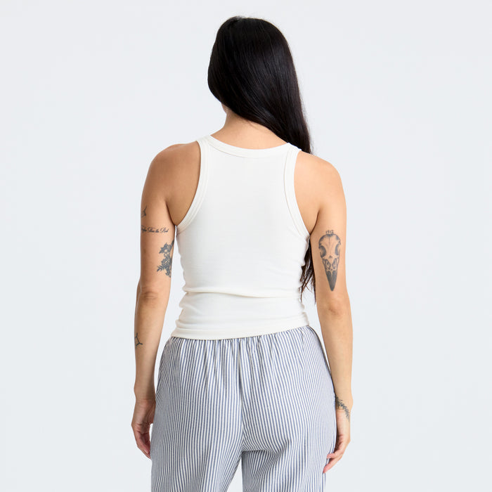 Model wearing a white sleeveless shirt with an outdoorsy style, emphasizing freedom and comfort, ideal for adventure and travel.